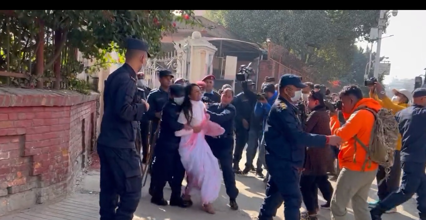सर्वोच्चको मुलढोकामा न्याय माग्दै रातो रङ छ्याप्ने सेतो पहिरन लगाएकी युवती प्रहरीको नियन्त्रणमा